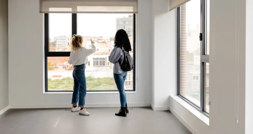 2 people looking out of window of a buy to let property