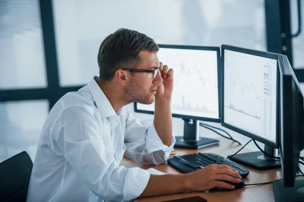 man sitting at computer working out capital gains