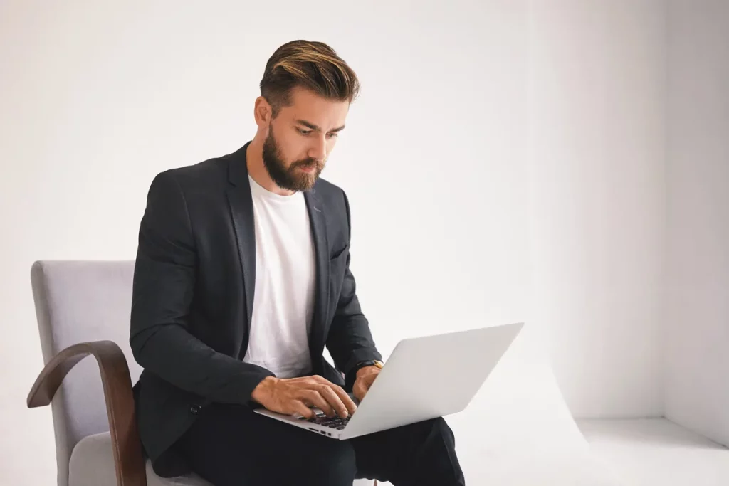 man looking at buy to let rental properties on a laptop