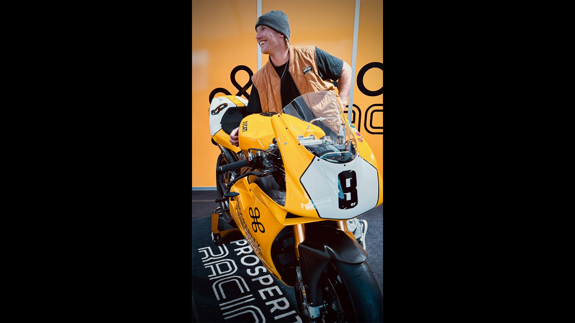 Yellow bike with man leaning over smiling.